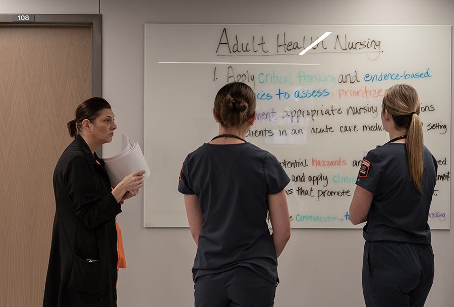 Nursing students and instructors at the whiteboard