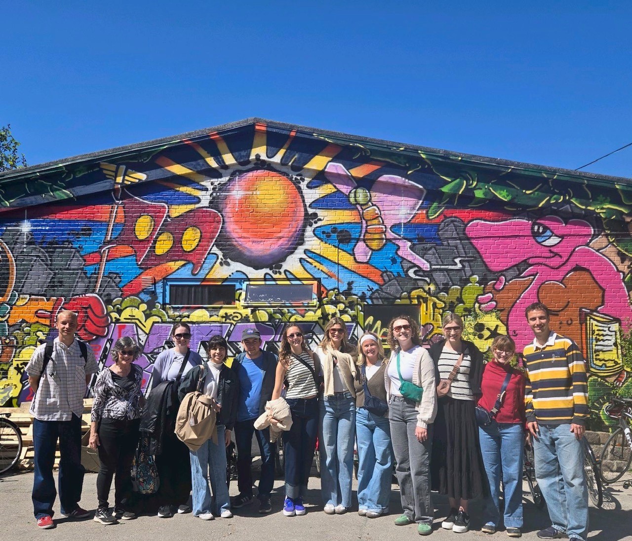 Students and faculty posing in front of a colorful building in Denmark